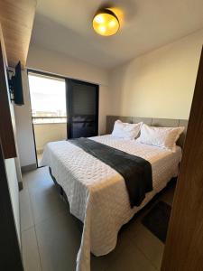 a bedroom with a large bed with a large window at Studio próximo a UFU Sta Monica e Center shopping in Uberlândia +63 photos