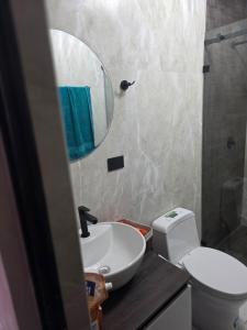 a bathroom with a sink and a toilet and a mirror at Verona house in Riobamba