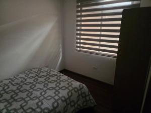 a bedroom with a bed and a window at Verona house in Riobamba