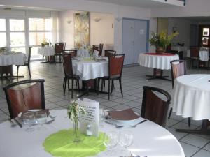 a dining room with white tables and chairs at Domaine de Mont-Evray in Nouan-le-Fuzelier