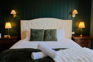 a bedroom with a large white bed with green walls at La Villa Dolce in Mount Victoria