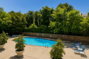 a swimming pool with blue chairs and trees at Lovely 2BR Condo WFH Heart of Downtown Pool Access in Atlanta