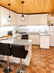 a kitchen with white cabinets and a wooden ceiling at Casa Aninhas in Sabrosa