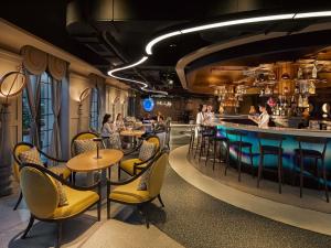 a restaurant with tables and chairs and a bar at Grand Mercure Dalat in Da Lat