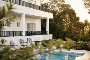 a white house with chairs and a swimming pool at Casa Blanca Tanay in Tanay +15 photos