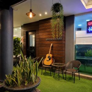 a room with a guitar and a table and chairs at Royal Queenspark Hotel in Malacca