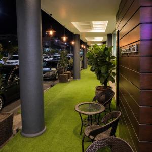 a room with a table and chairs on a green lawn at Royal Queenspark Hotel in Malacca
