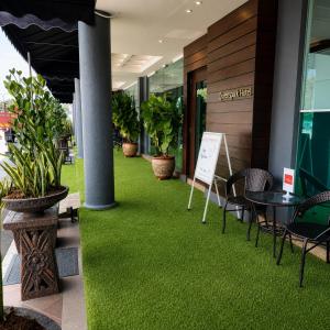 a walkway with green grass in front of a building at Royal Queenspark Hotel in Malacca