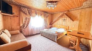 a bedroom with a bed and a couch in a room at "Як вдома" Буковель in Bukovel +71 photos