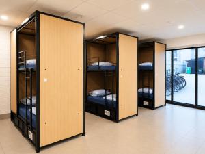 a row of lockers with beds in them in a room at Perth City Backpackers Hostel - note - Valid passport required to check in in Perth