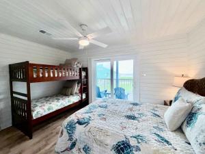 a bedroom with a bed and a ceiling fan at Sandy Beach Retreat and Gulf View in Galveston