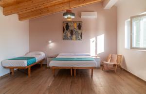 two beds in a room with wooden floors at Fili d'Erba Cilento in Villammare