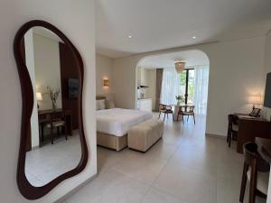 a bedroom with a bed and a large mirror at Lumix Residence in Munggu