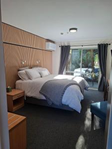 a bedroom with a bed and a large window at La Rochelle Motel in Akaroa