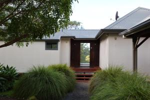 a white house with a porch and some grass at The Siding Yallingup in Yallingup