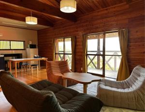 a living room with a couch and chairs and a table at Maruta なんもく村 in Minamimaki