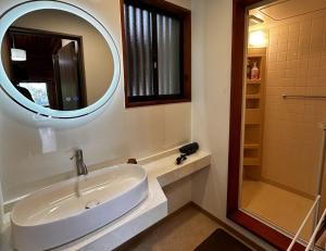 a bathroom with a sink and a mirror at Maruta なんもく村 in Minamimaki