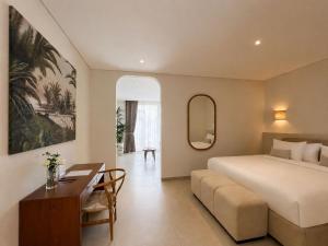 a hotel room with a bed and a desk at Lumix Residence in Munggu