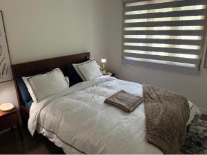 a bedroom with a bed with white sheets and a window at La Pergola-6 in Quebec City