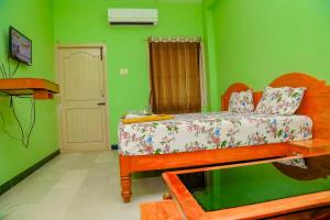 a bedroom with a bed in a green room at Park Palace Inn in Erode