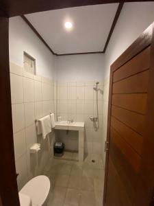 a bathroom with a toilet and a sink at The Lonceng hotel in Badung +18 photos