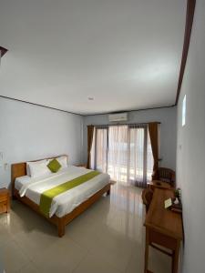 a bedroom with a bed and a large window at The Lonceng hotel in Badung