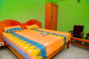 a bedroom with a large bed with a colorful blanket at Park Palace Inn in Erode