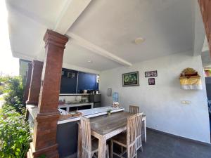 a kitchen with a wooden table and a counter at The Lonceng hotel in Badung