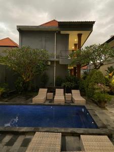 a house with a swimming pool in front of a house at The Lonceng hotel in Badung