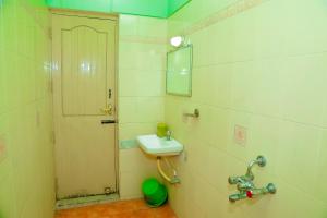 a bathroom with a sink and a mirror and a door at Park Palace Inn in Erode