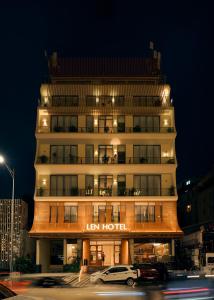 a hotel building with cars parked in front of it at Len Hotel in Da Lat
