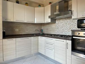 a kitchen with white cabinets and stainless steel appliances at Italian charm, modern elegance in Pizzo in Pizzo