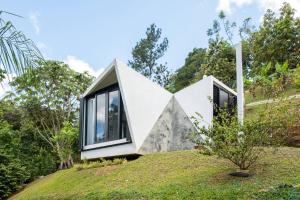 a house on top of a grassy hill at Farm Suite Bienteveo in Naranjito