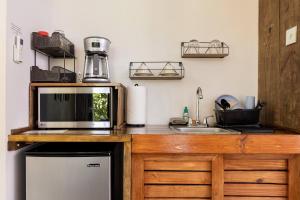 a kitchen counter with a microwave and a sink at Farm Suite San Pedrito in Naranjito +10 photos