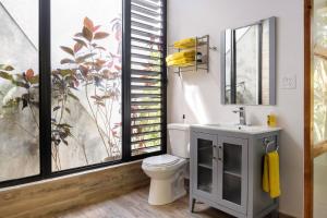 a bathroom with a toilet and a sink and a window at Farm Suite San Pedrito in Naranjito