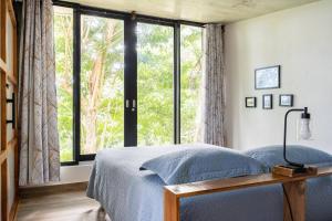 a bedroom with a bed and a large window at Farm Suite San Pedrito in Naranjito