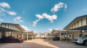 a couple of cars parked in a parking lot at Caboolture Gateway Motel in Caboolture