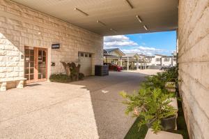 a building with a walkway leading into a driveway at Caboolture Gateway Motel in Caboolture +7 photos