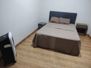 ein Schlafzimmer mit einem Bett und zwei Nachttischen in der Unterkunft Edificio Las Palmas in Tumbes