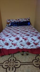 a bed with a bedspread with roses on it at O-t on the rise in Tweedside