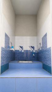 a bathroom with three dolphins on the wall at Mahadev Guest House in Deoghar