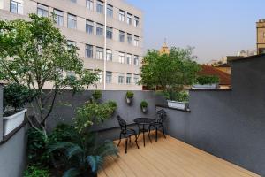a balcony with two chairs and a table on a building at Atour on the Bund in Shanghai