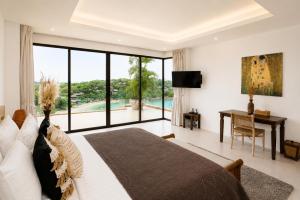 a bedroom with a bed and a desk and a large window at Casa Nicola Amazing Sea View Villa in Koh Samui in Nathon Bay