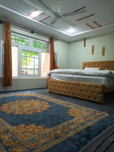 a bedroom with a bed and a rug at Stone Leaf Retreat - Skardu in Skardu