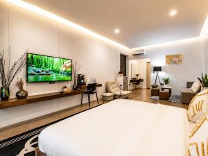 a bedroom with a bed and a tv on a wall at YUSETH Private Villa in Phumi Ta Phul