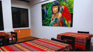 a room with two tables and a painting on the wall at Hostal Mariscal Sucre in Tababela