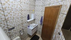 a bathroom with a toilet and a wooden door at Casa aconchegante A , 4 minutos do thermas in Andradina +11 photos