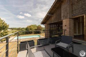 a balcony of a house with a swimming pool at La busquette in Villaudric