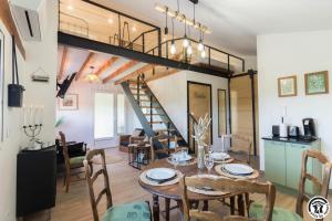 a dining room and living room with a loft at La busquette in Villaudric