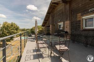 a deck with a glass table and chairs at La busquette in Villaudric